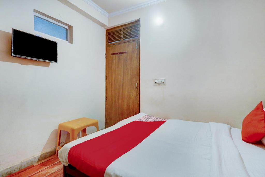 a bedroom with a bed and a flat screen tv at Hotel O Ratiram in Kalkaji Devi