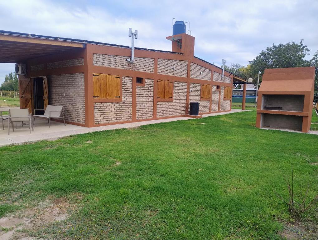 a brick building with a lawn in front of it at FiNCA DACA in Junín