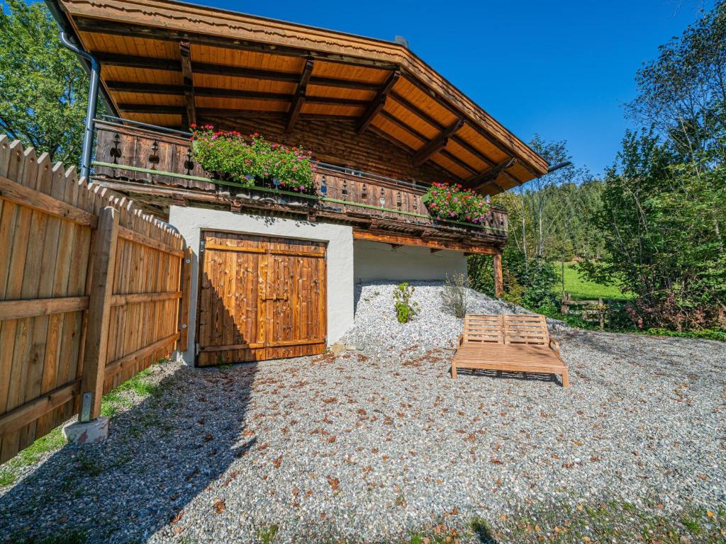a house with a wooden gate and a wooden fence at Die Kramerei in Hollersbach im Pinzgau