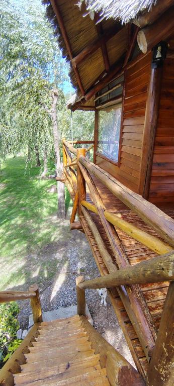 a porch of a wooden cabin with a wooden bench at Cabañas Manantiales de Obligado in San Pedro