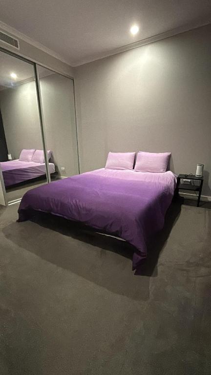 a bedroom with a large purple bed with mirrors at nomads abode in Liverpool