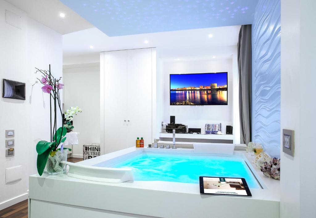 a bathroom with a large swimming pool in a room at F53 Kevin's Charming Houses in Alghero