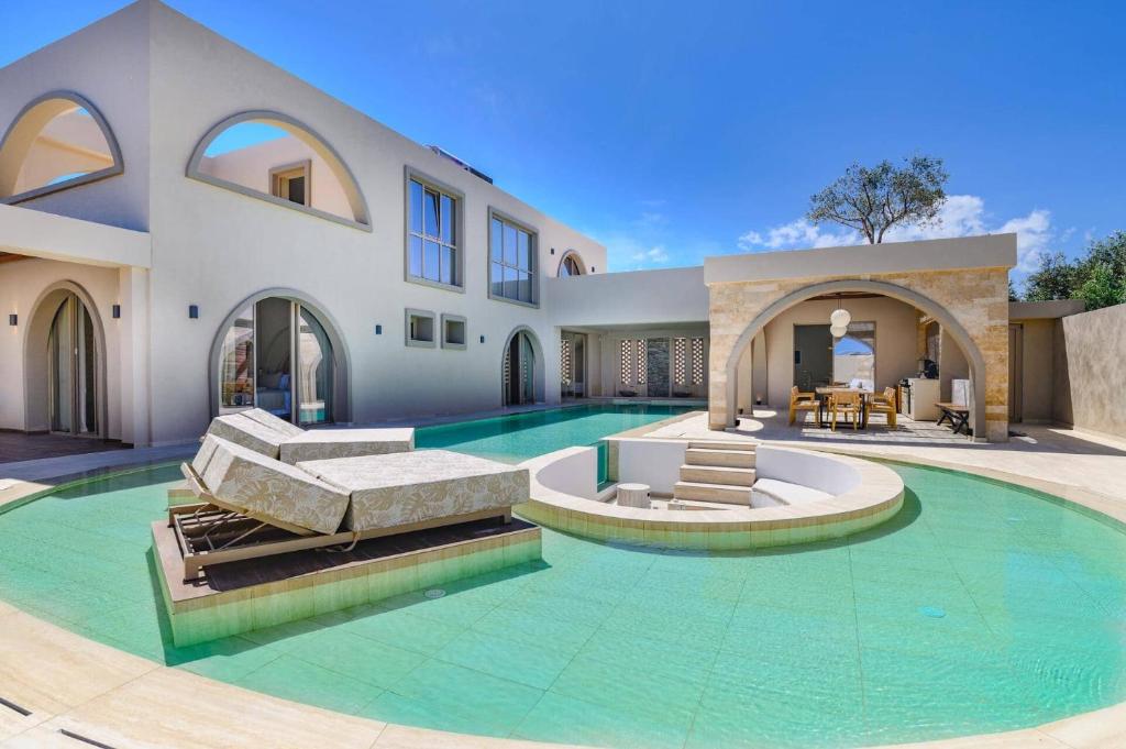 a large house with a swimming pool in front of it at Villa Lavender by Villa Plus in Kolymbia