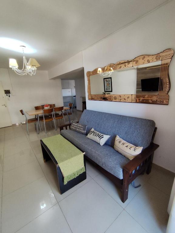 a living room with a blue couch and a table at Depto céntrico de 3 habitaciones y cochera in Rosario