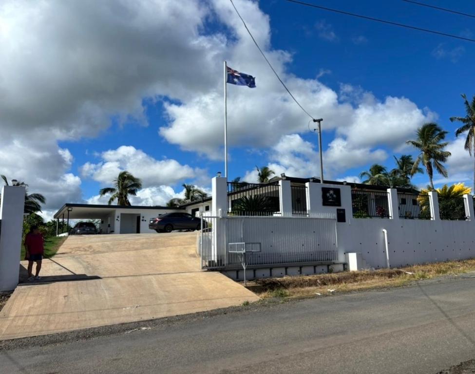 a white house with a flag on top of it at Naikabula Villa in Lautoka