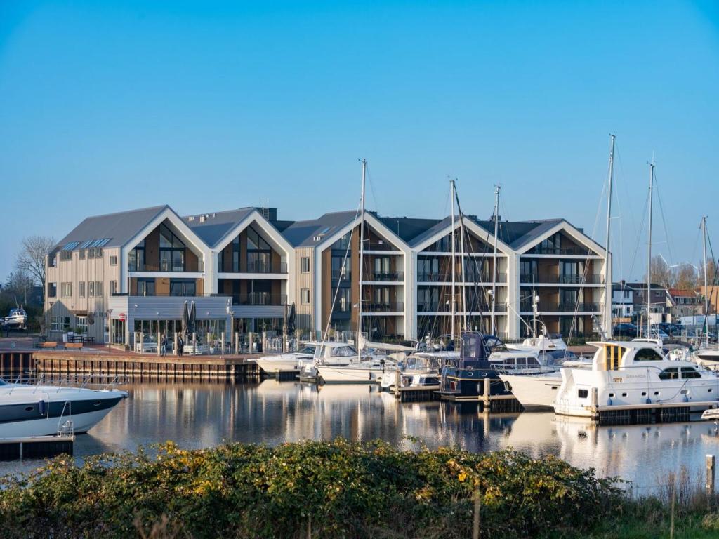 a marina with boats docked in front of a building at De Havenkamer in Kamperland