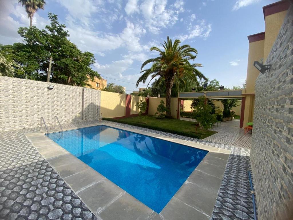 a swimming pool in front of a house at Villa Sais avec piscine in Meknès