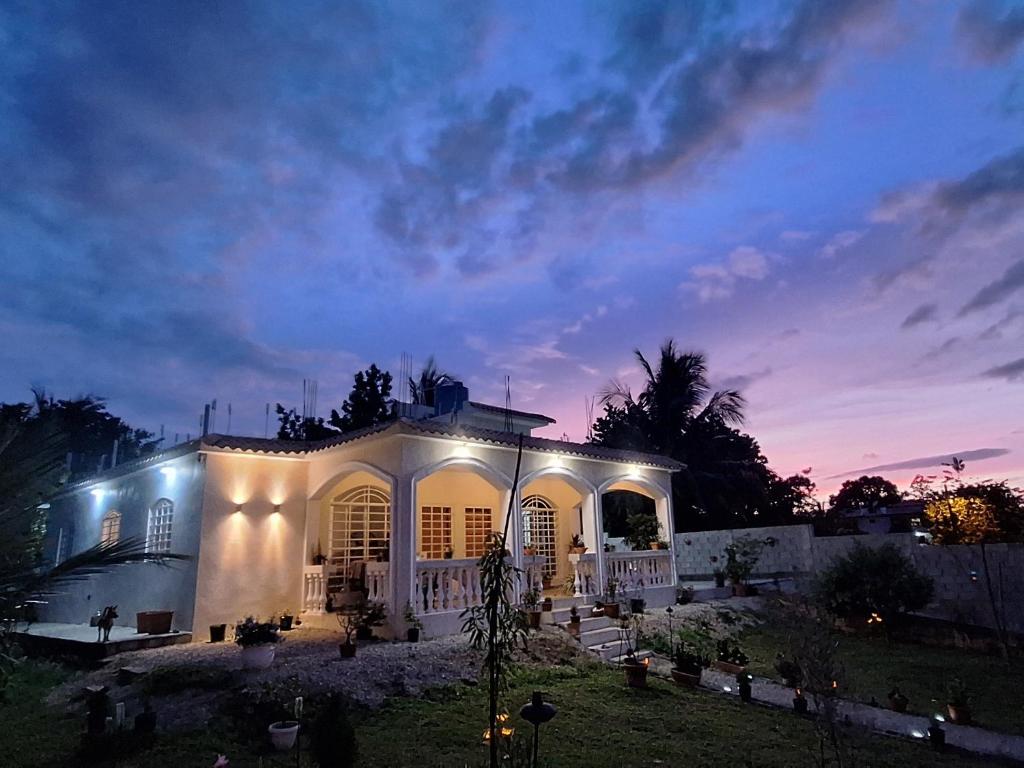 a white house with lights in the yard at night at CasaMia RD B&B in Río San Juan
