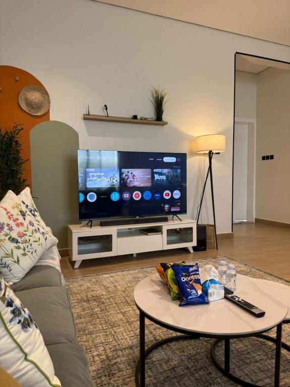 a living room with a couch and a tv at شقة الدانة وصول ذاتي القيصومه in Hafr Al-Batin