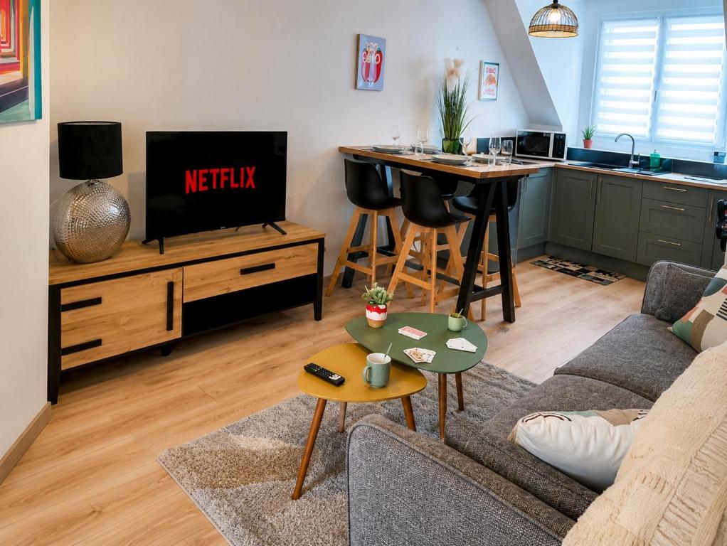 a living room with a couch and a kitchen at Le Duplex Port & Plage in Dieppe