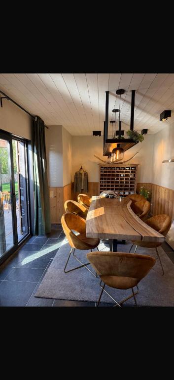 een eetkamer met een houten tafel en stoelen bij Saintbarth in Houyet