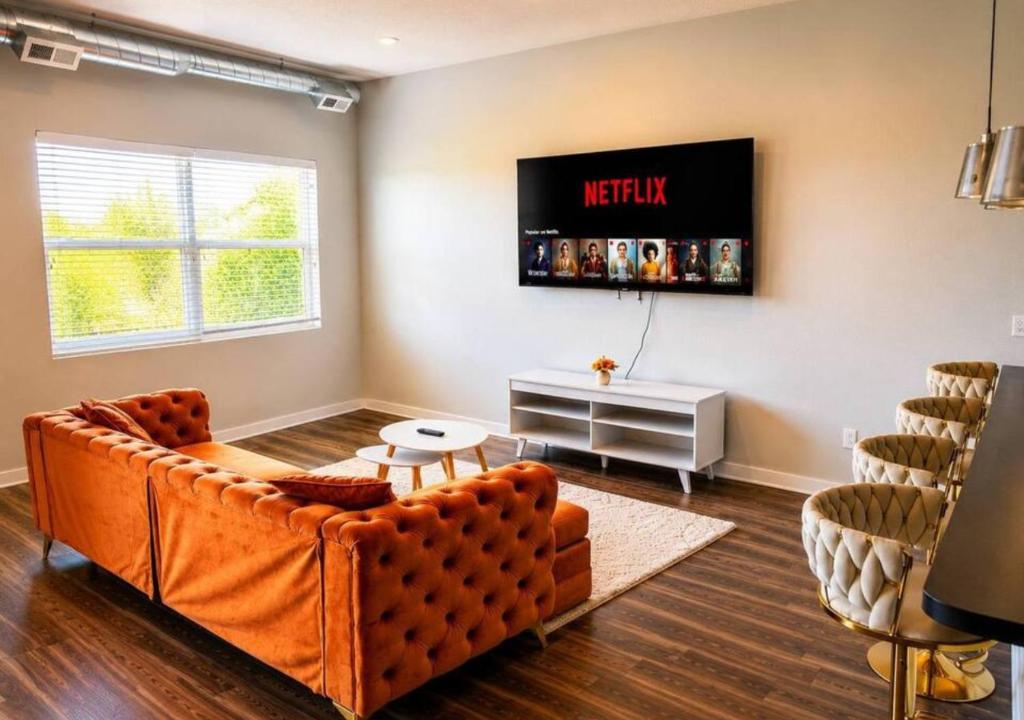 a living room with a couch and a tv on the wall at Casa Marigold in Des Moines