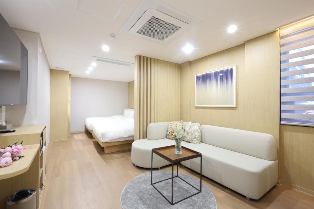 a living room with a couch and a bed at Busan Seomyeon Nestly Hotel in Busan
