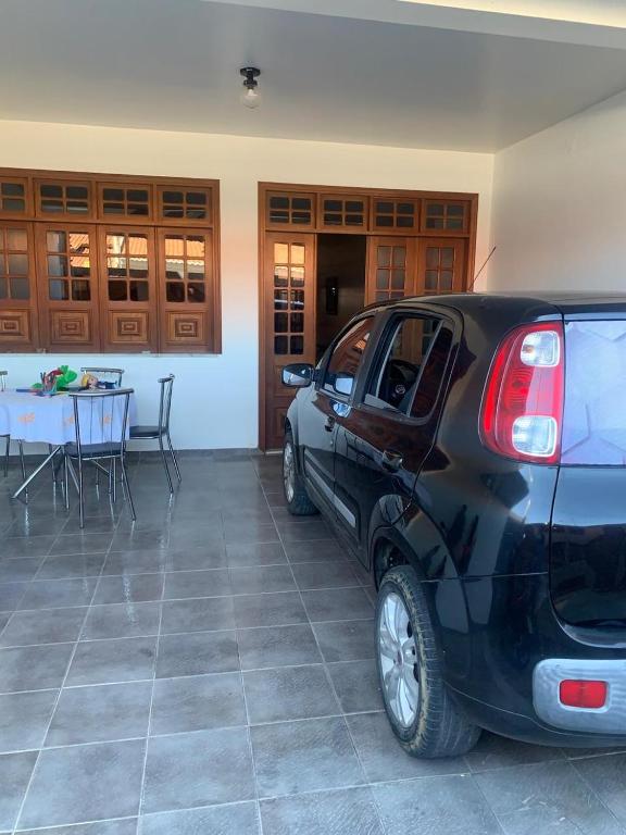 a black car parked in a garage with a table at Quartos petrolina 02 in Petrolina