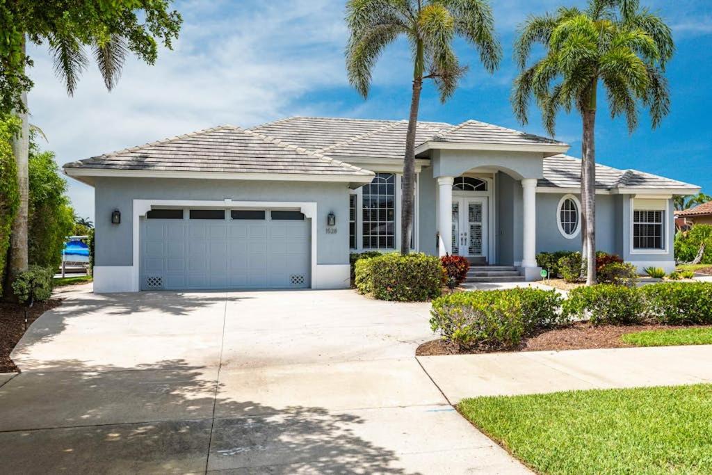 a house with palm trees in front of it at Marco Island Majesty in Marco Island