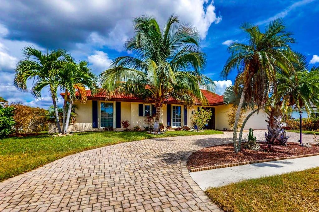 a house with palm trees in front of it at Marco Island Manor in Marco Island