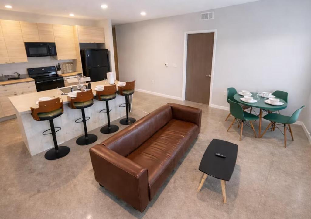 a living room with a couch and a table and chairs at Cozy Greenwood Canopy in Des Moines