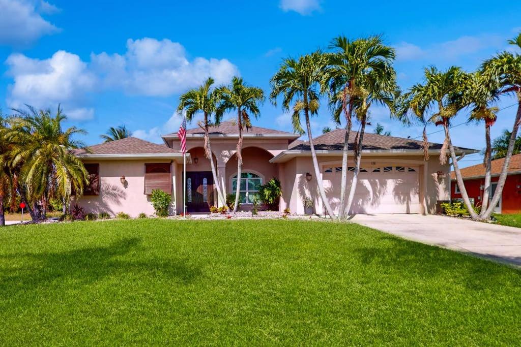 a house with palm trees in front of it at Endless Summer in Cape Coral