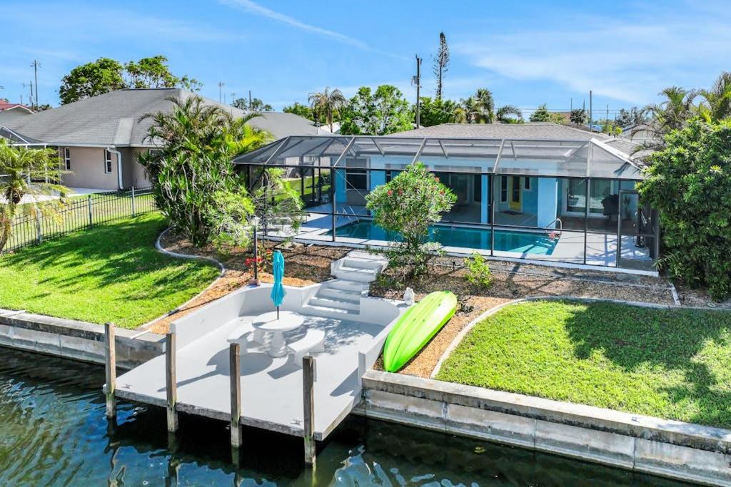 a house with a boat in the water at Three Palms Retreat in Cape Coral