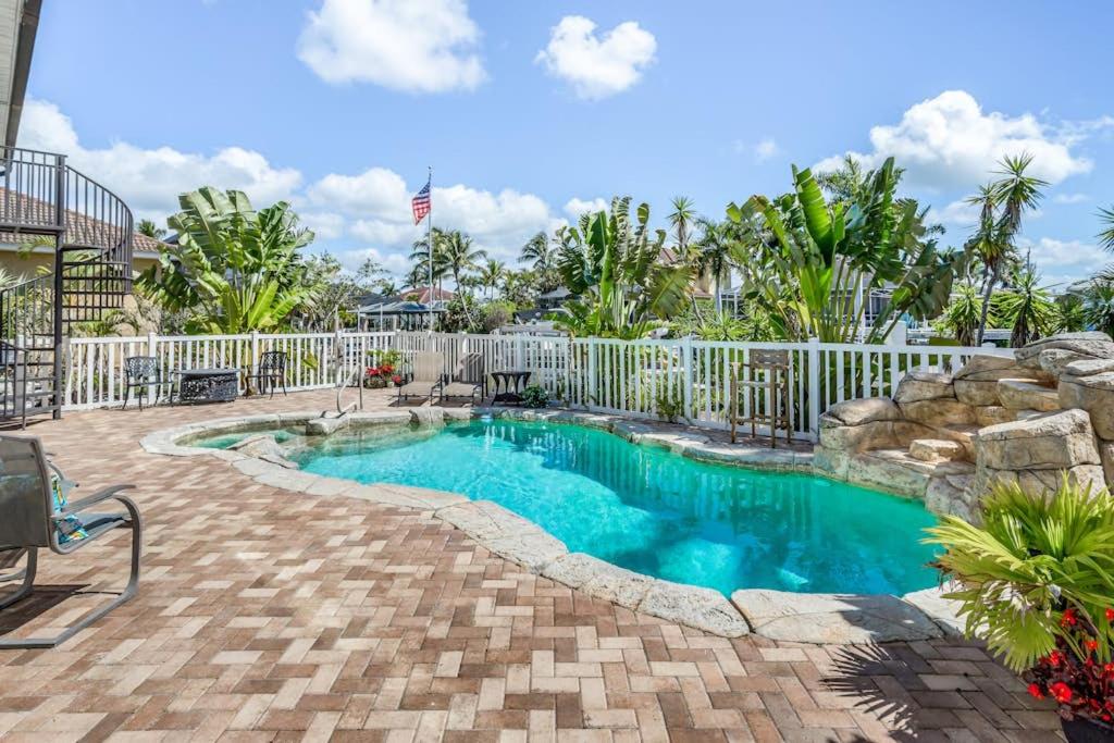 a swimming pool in a yard with a fence at Madagascar Palm in Marco Island