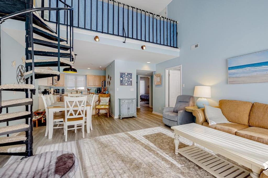 a living room with a couch and a spiral staircase at Sea Colony --- 2403 Round Robin in Bethany Beach