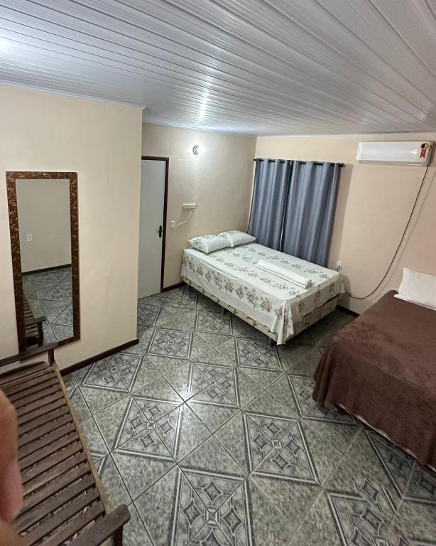 a hotel room with two beds and a mirror at cantinhoannajullyaatins in Atins