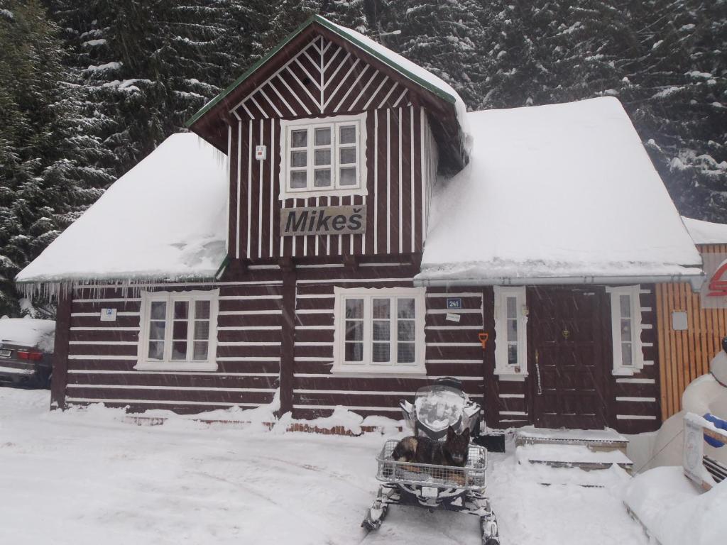 a small house with a sled in front of it at Penzion Mikeš in Pec pod Sněžkou