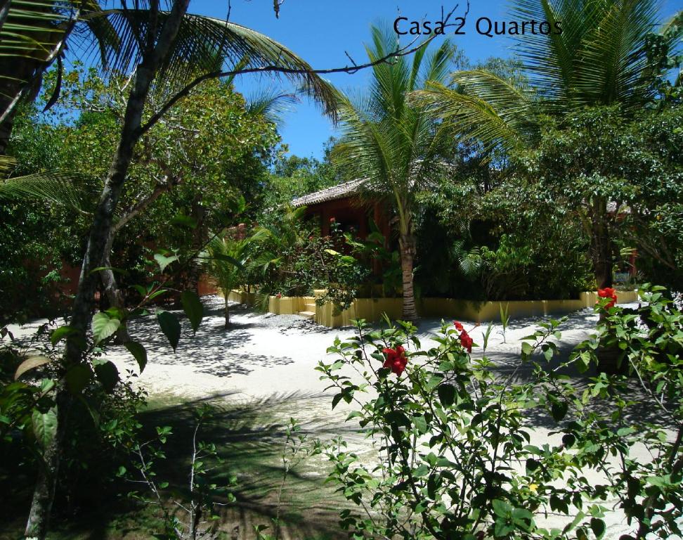 un giardino con palme e una casa di Condominio dos Nativos a Trancoso
