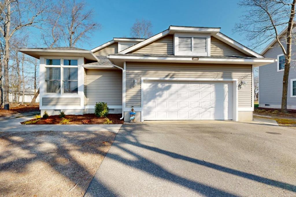 a white house with a garage on a driveway at Salt Pond - 1 Heron Ct in Bethany Beach