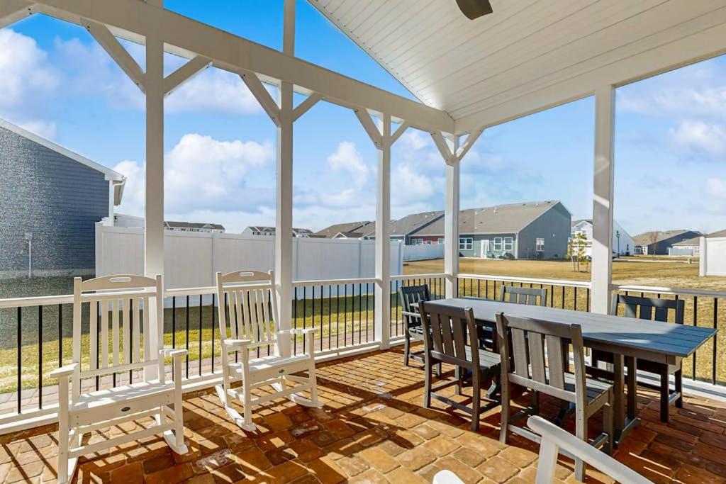 a porch with a table and chairs and a fence at Millville By The Sea in Millville