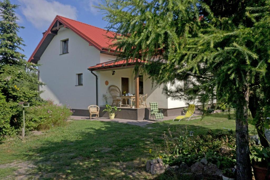 Casa blanca con techo rojo y patio en Agroturystyka pod Czarną Sosną, en Biały Ług