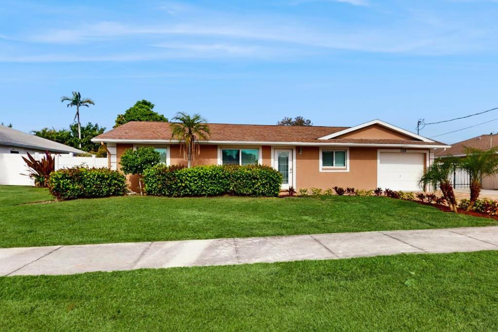 a house with a green lawn in front of it at Mango House in Naples