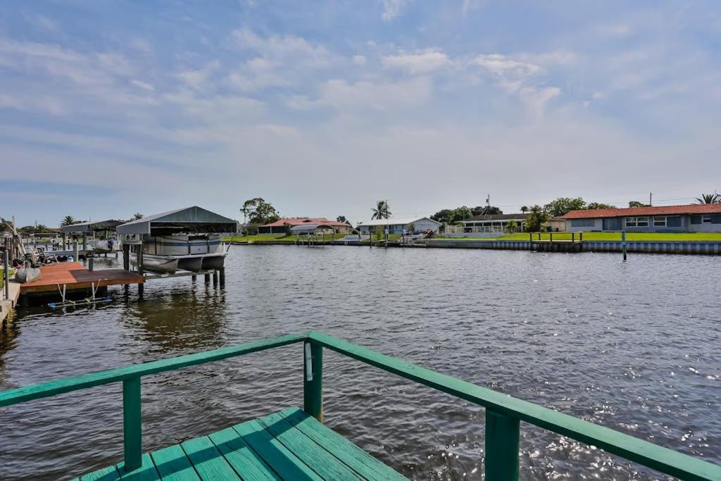 a boat on a river with a dock and houses at Tarpon Lagoon in Port Charlotte