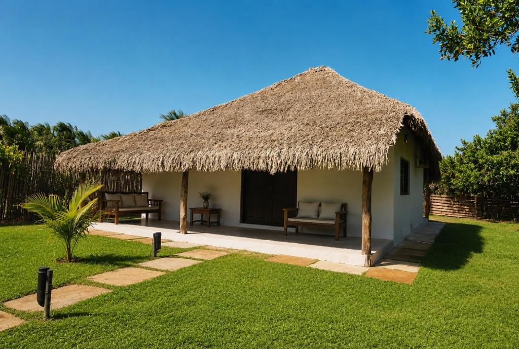 a small hut with a grass roof and a yard at Kite Mansion Arpoador in Tutóia