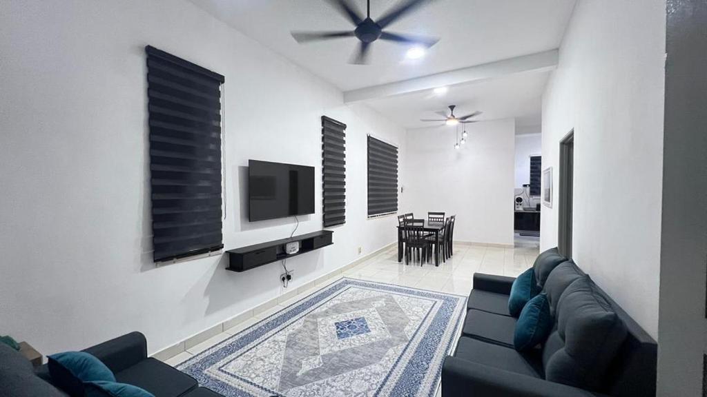 a living room with a couch and a tv at Razumi's Homestay 3 in Arau