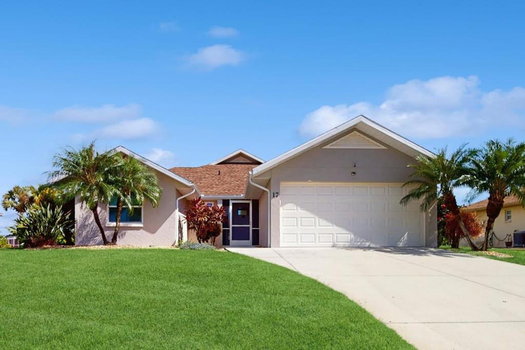 a house with palm trees and a driveway at Waterway Whispers in Rotunda-West