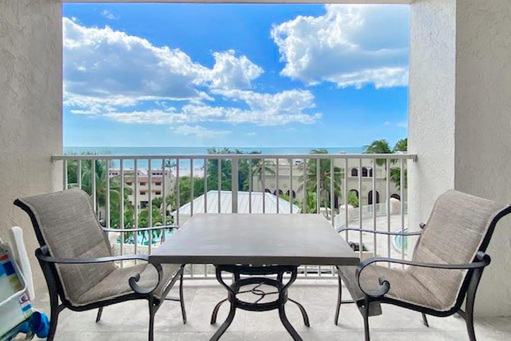 a patio with a table and two chairs on a balcony at Marco Beach Ocean Resort 807 in Marco Island