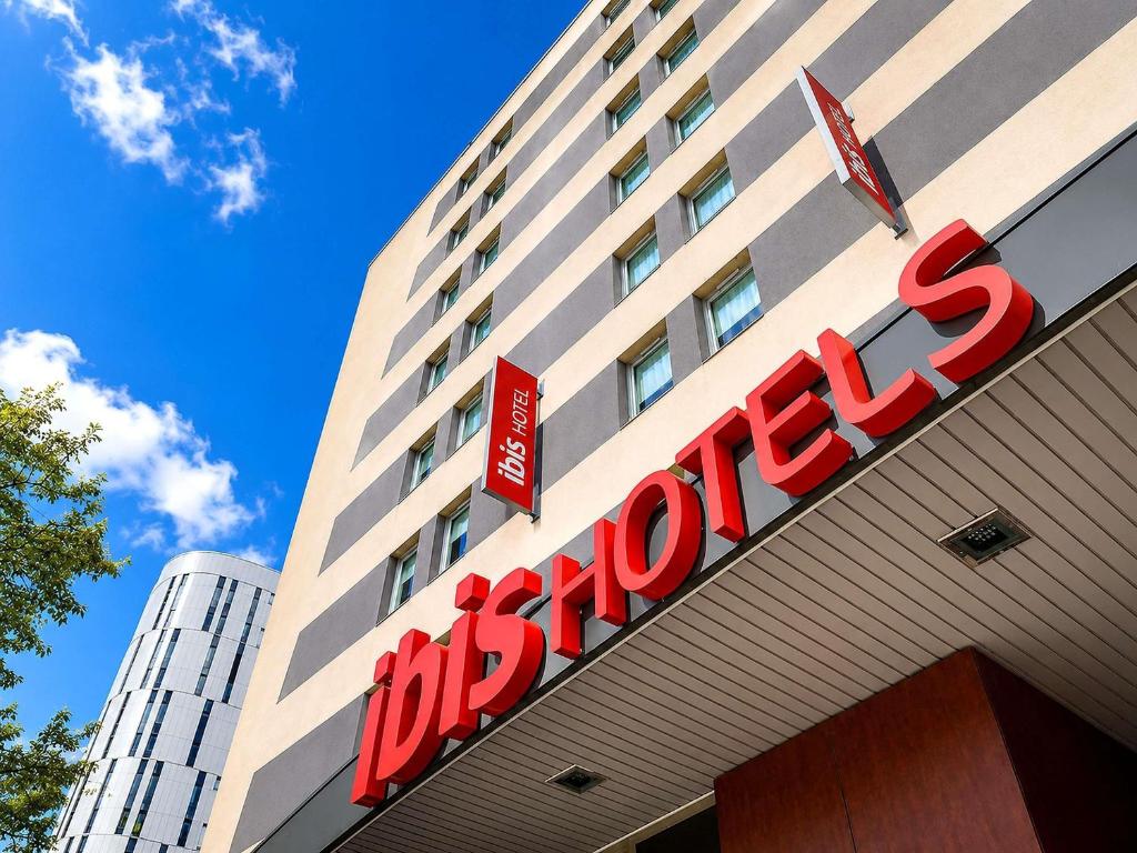 a building with a red sign on top of it at Hotel ibis Dijon Centre Clemenceau in Dijon