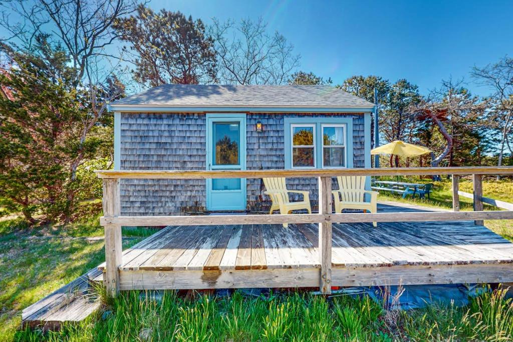 a blue tiny house with two chairs on a wooden deck at North Truro Bayside Gem in Truro