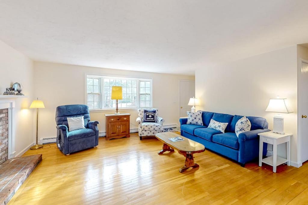 a living room with a blue couch and chairs at Corner Cottage in Chatham