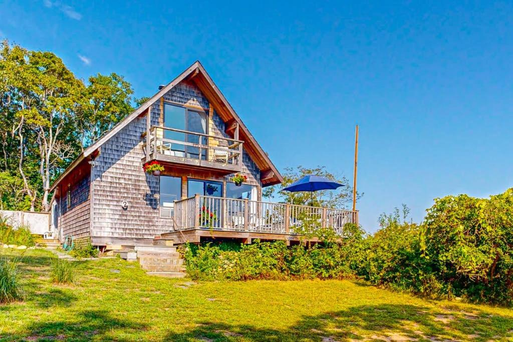a house with a balcony and an umbrella at Lobsterville Landing in Lobsterville