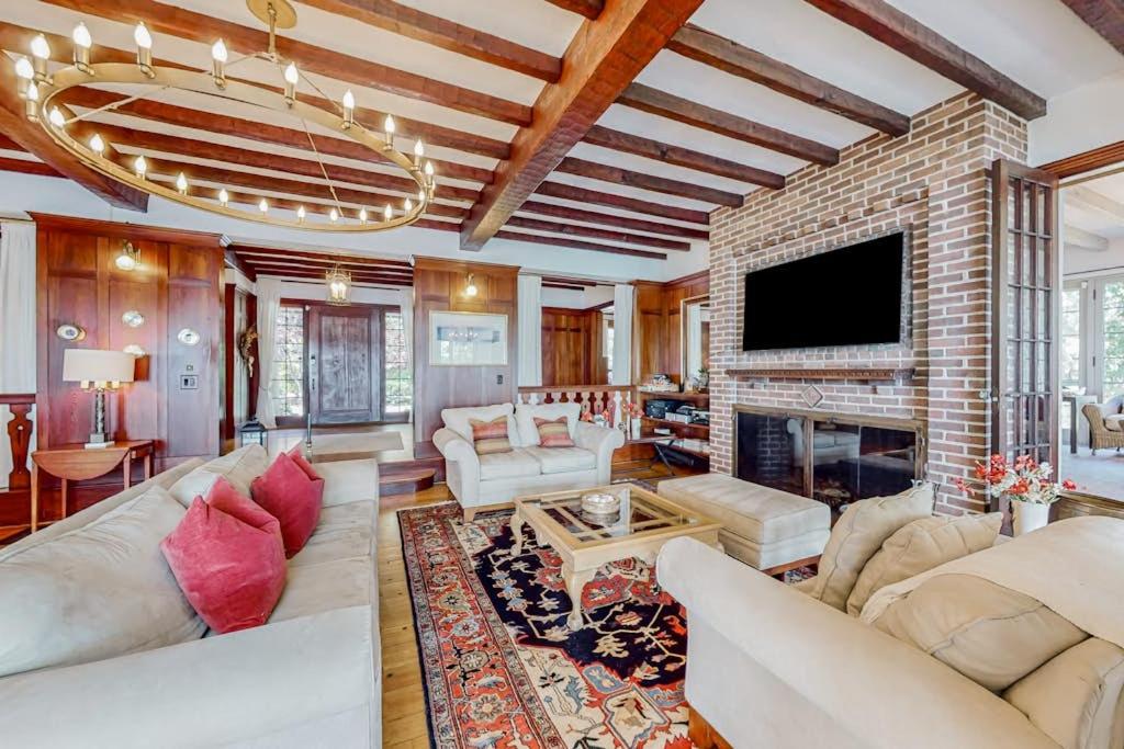 a living room with couches and a brick fireplace at Capeview Estate in Bourne