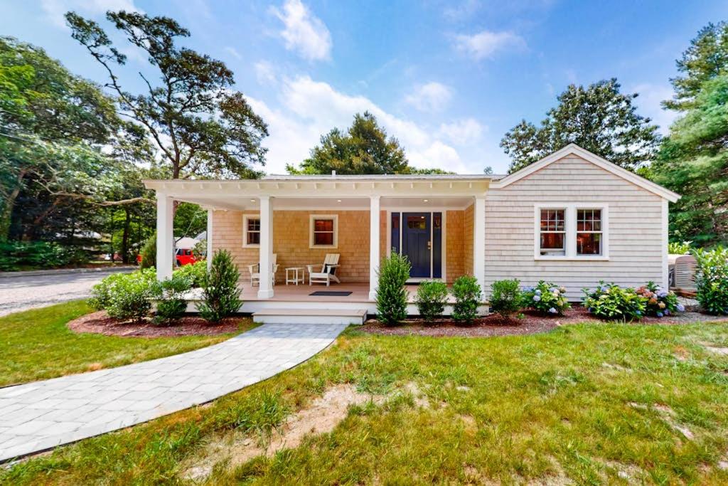 a small white house with a porch at The Cape House in Cotuit