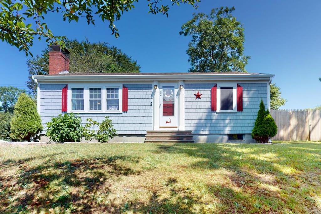 a small blue house with a red door at Downtown Seaside Serenity Retreat in Hyannis