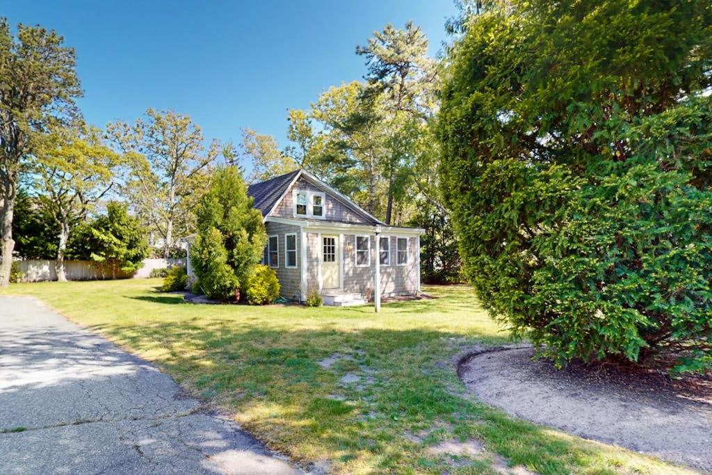 an old house in a yard with a driveway at Belmont Beach Cottage in West Harwich