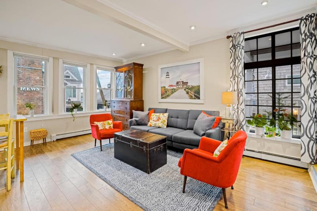 a living room with a couch and orange chairs at Lady Burns' Lookout in Provincetown