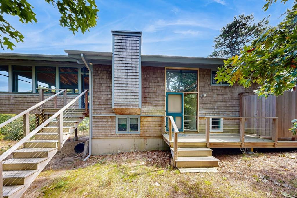 a brick house with a staircase in front of it at Drummer Cove Retreat in Wellfleet