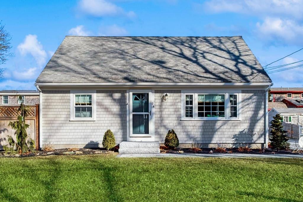 a house with a green lawn in front of it at Seabreeze Escape in Falmouth