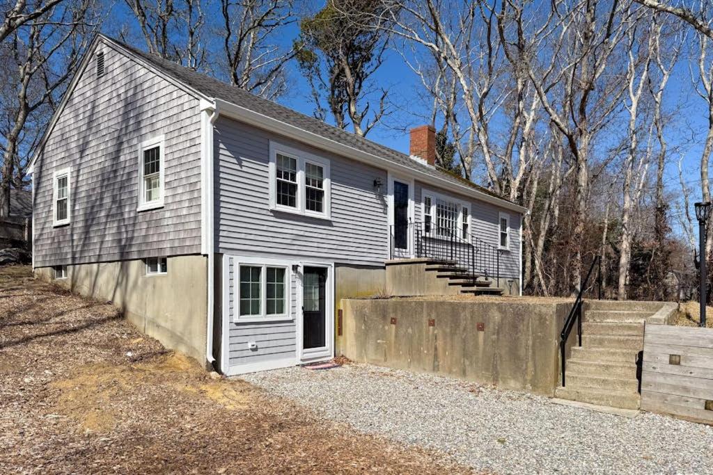 a gray house with a garage and a fence at Champagne Dreams in Dennis