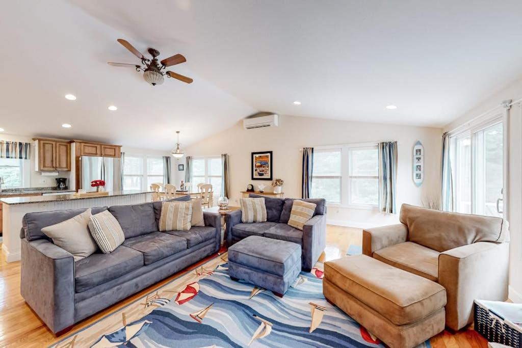 a living room with a couch and chairs and a kitchen at Osterville Odyssey in Osterville